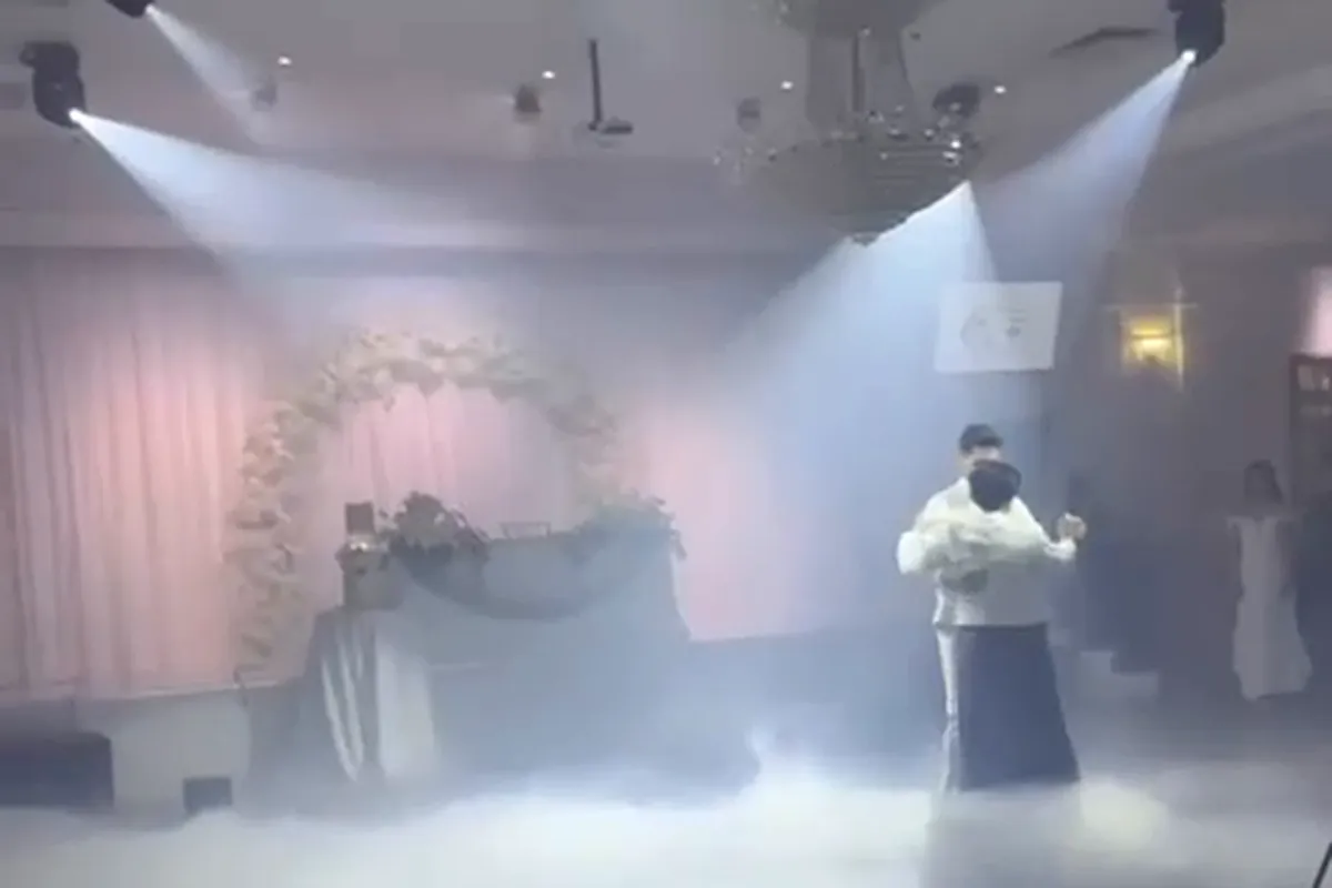 A couple's first dance surrounded by low-lying haze